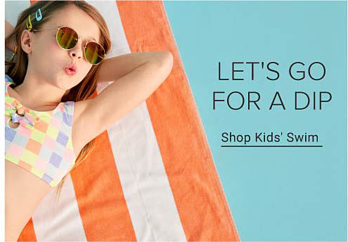 Young girl relaxing by the pool wearing sunglasses and a colorful bathsuit. Let's go for a dip. Shop kids' swim.