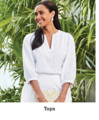 An image of a woman wearing a white blouse. Shop tops.