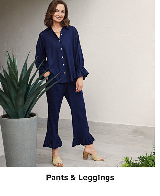 An image of a woman wearing a navy shirt and pant set. Shop pants and leggings.