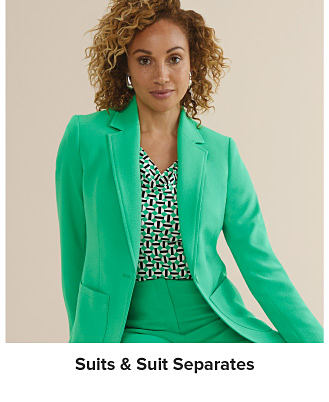 An image of a woman wearing a green suit and printed blouse. Shop suits and suit separates.