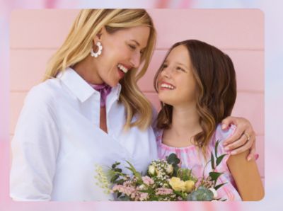 A woman holds a bouquet of flowers with her daughter. Celebrate in style.