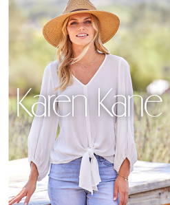 A woman wearing a white tie front long sleeve blouse, jeans and a beige hat. Karen Kane.