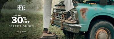 Close up image of a person wearing sandals in front of a pickup truck. Frye logo. Up to 30% off select shoes. Shop now.