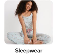 A woman in a pajama set. Shop sleepwear.