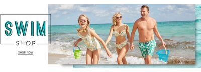 A man, a woman and a girl at the beach in their bathing suits. Swim shop. Shop now.