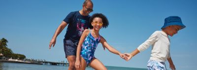 An image of a family at the beach wearing swimwear.