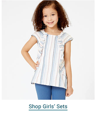 A girl in a striped top and jeans. Shop girls sets.
