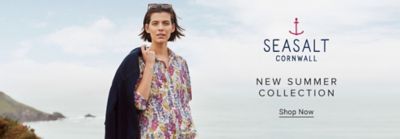 A woman in a patterned shirt and white pants. Seasalt Cornwall logo. New summer collection. Shop now.