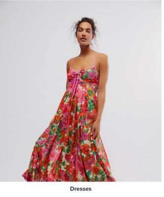 An image of a woman wearing a floral dress. Shop dresses.