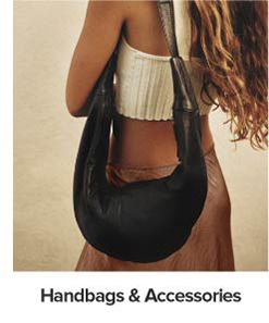 An image of a woman carrying a handbag. Shop handbags and accessories.