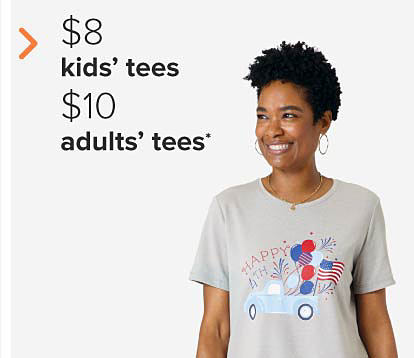 A woman in a tee that says happy fourth and has a photo of a light blue pickup truck with a flag and red, white and blue balloons in the back. $8 kids' tees and $10 adults' tees. 