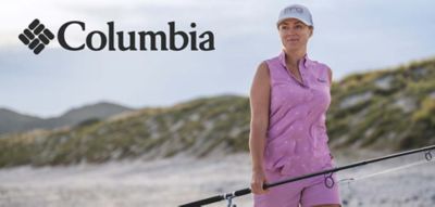 An image of a woman wearing Columbia apparel on the beach. The Columbia logo.