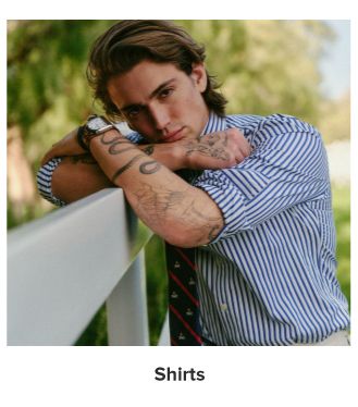 A man in a blue and white striped button up. Shirts.