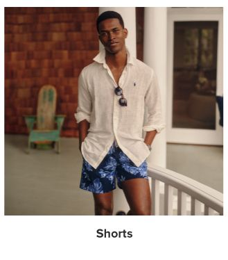 A man in a white button up and blue shorts. Shorts.