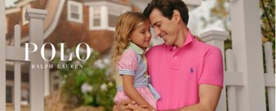 Man in pink polo shirt holding girl in striped dress. Polo Ralph Lauren. 