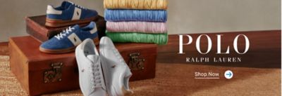 Blue and white sneakers displayed with folded colorful shirts on wooden trunk. Polo Ralph Lauren. Shop now.
