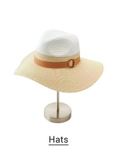 A beige and white beach hat with a brown strap at the base of the brim. Hats.