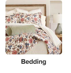 An image of a bed with floral bedding and pillows to match. Bedding.