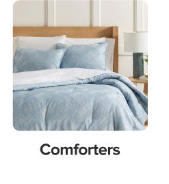 Blue comforter on white bedding. Shop comforters.