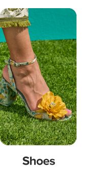 A green high heel with a yellow flower on it. Shop shoes.