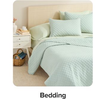 A bed with plaid and green bedding. Shop bedding.