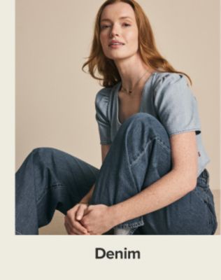 A woman in a light blue top and jeans. Shop denim.