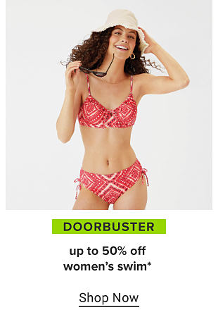 A woman in a sun hat and a red bikini with white and black accents. Doorbuster, up to 50% off women's swim. Shop now. 