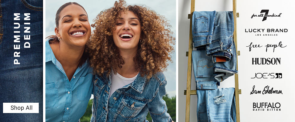 Premium denim. Shop all. An image of two women wearing denim outfits. An image of jeans hanging up next to a variety of denim brand logos.