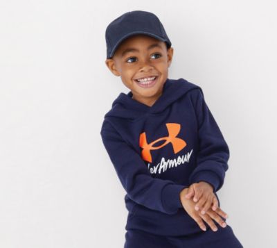 A boy in a blue hat and blue Under Armour sweatshirt. The active shop.