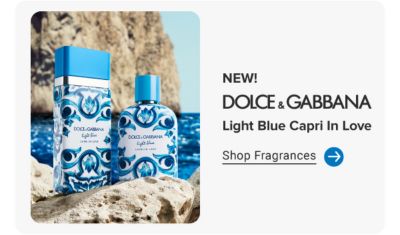NEW! Dolce & Gabbana Light Blue Capri In Love. Shop fragrances. Dolce & Gabbana perfume bottles on a rock in front of the ocean.