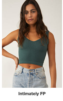 A woman in a green tank and blue jeans. Intimately FP. 