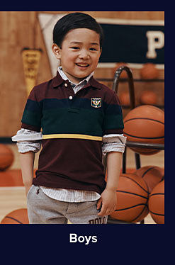 An image of a boy posing on a basketball court. Shop boys. 