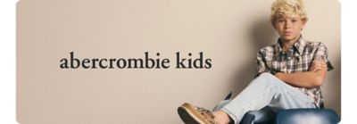 A boy in blue jeans and a plaid shirt. Abercrombie kids