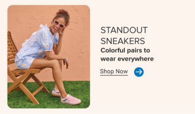 A woman sitting on a chair in a blue set and pink shoes. Standout sneakers. Colorful pairs to wear everywhere. Shop now.
