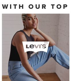 A woman in a black top and blue jeans. Levi's