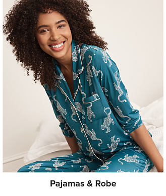 Image of a woman wearing a patterned blue pajama set. Pajamas and robes