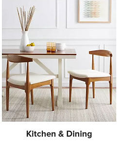 An image of a small dining table with wood chairs topped with white cushions. Shop kitchen and dining. 