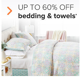A bed with pastel green, purple and yellow bedding. Up to 65% off bedding and towels. 