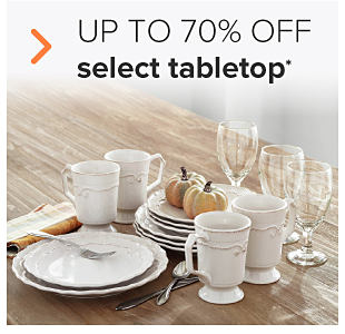An assortment of white ceramic plates, white ceramic bowls and wine glasses. Small pumpkins sit on top of the plates. Up to 70% off select tabletop. 