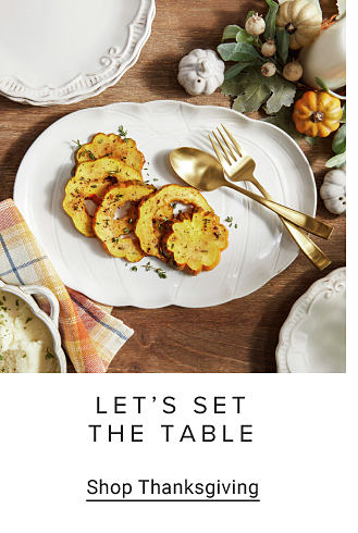 A white dish with food on it and gilded cutlery. Let's set the table. Shop Thanksgiving.