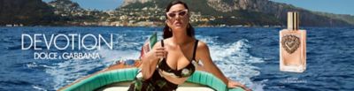 Katy Perry lounges on a boat, somewhere off the coast of Italy. A bottle of Dolce and Gabbana Devotion perfume. Dolce and Gabbana Devotion. Shop now.