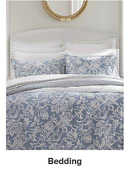  Image of a bed with blue and white bedding. Shop bedding.