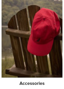 An image of a red hat hanging off the back of an outdoor chair. Shop accessories.