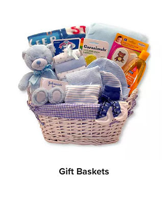 A pink basket filled with a teddy bear, baby bath, towels and other baby essentials. Gift Baskets. 