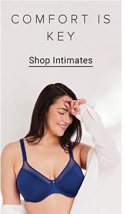 Woman wearing a navy blue bra and white cardigan. Comfort is key. Shop intimates.