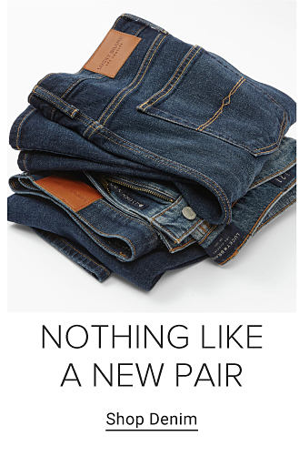 A stack of folded blue jeans. Nothing like a new pair. Shop denim.