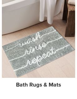 An image of a gray bath towel with the words wash, rinse, repeat on it. Shop bath rugs and mats.