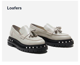 An image of white loafers with a black sole. Shop loafers.