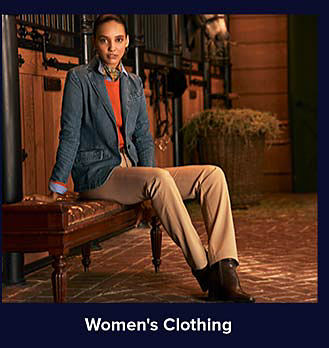 An image of a woman in a blue blazer, orange sweater and khaki pants. Shop women's clothing.