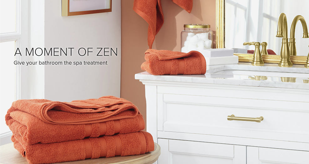 A bathroom with orange towels stacked on the counter. A moment of zen, give you bathroom the spa treatment.